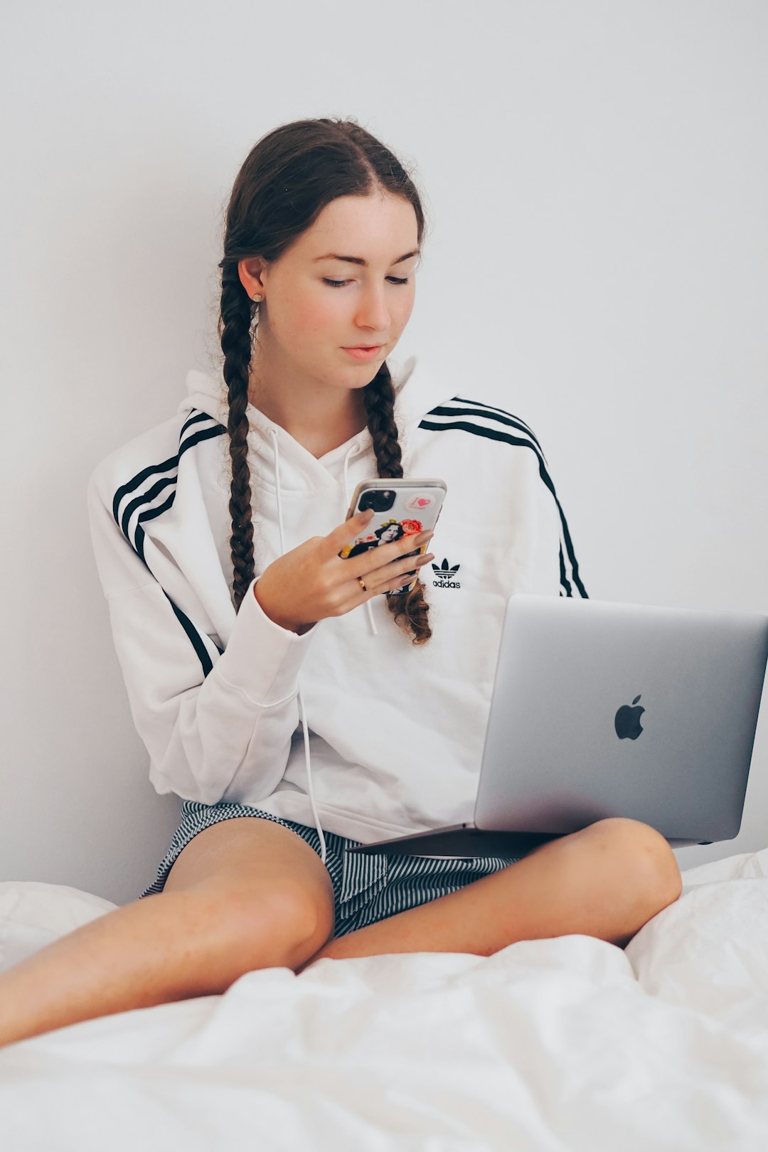 woman in white coat sitting on bed using silver macbook — Photo by Laura Chouette on Unsplash